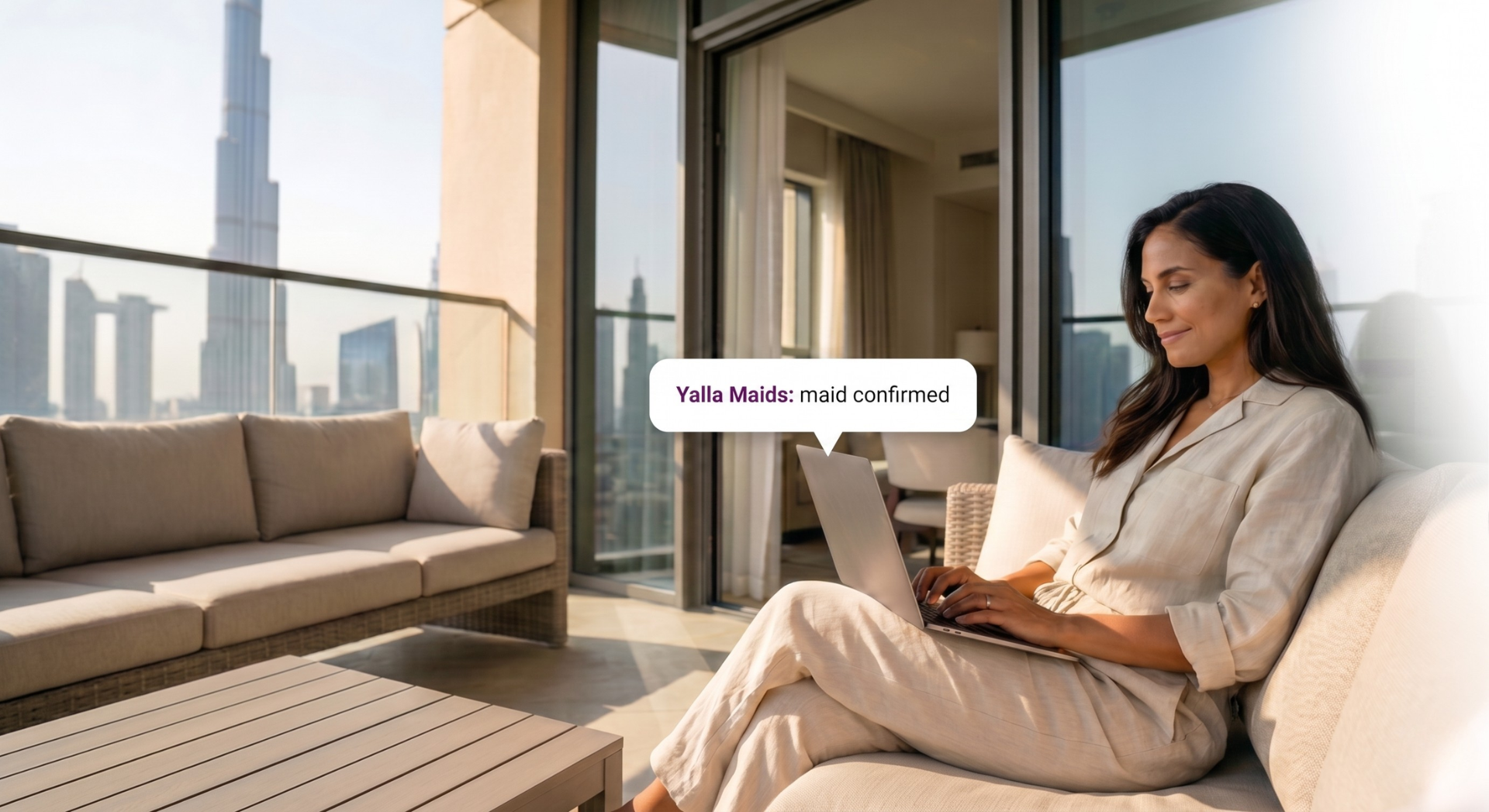 Tadbeer Dubai alternative service with a Dubai resident receiving maid confirmation from Yalla Maids on a laptop at home.