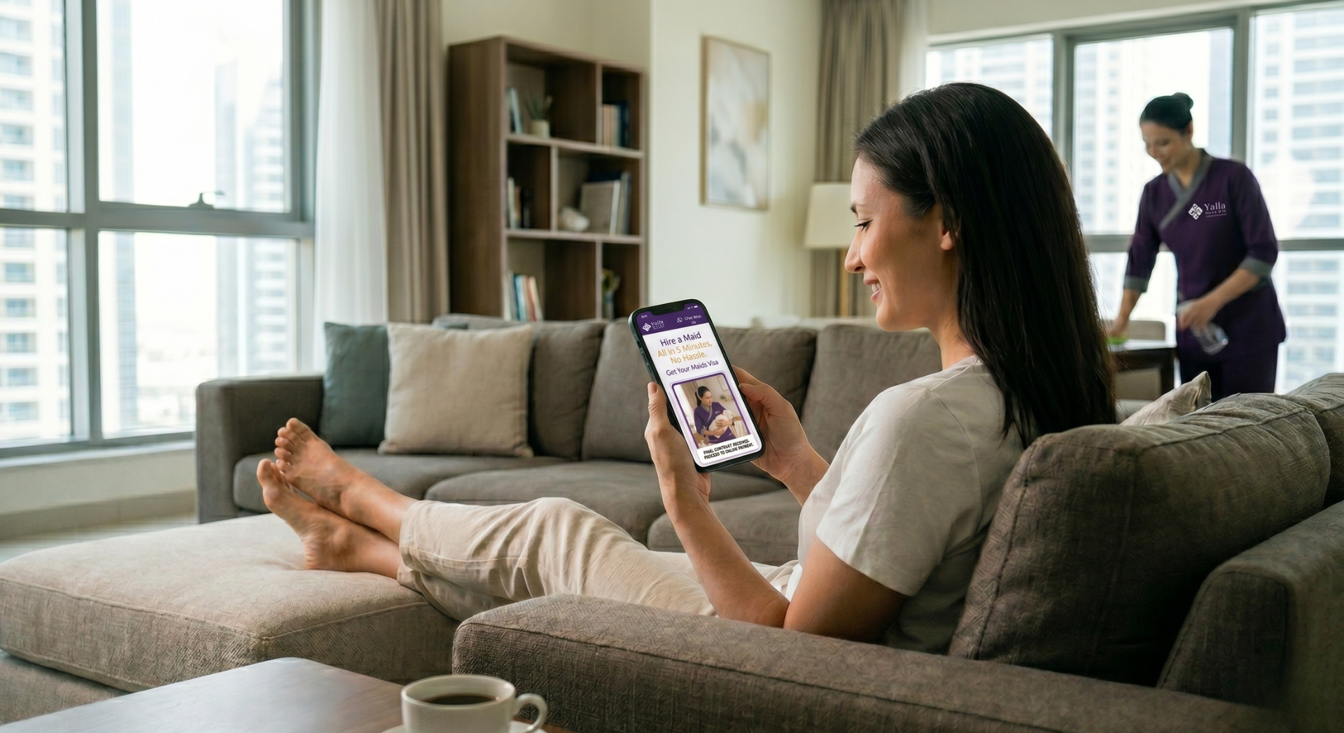 Woman relaxing on sofa using mobile app to hire a maid in Dubai while a uniformed housemaid cleans in the background.